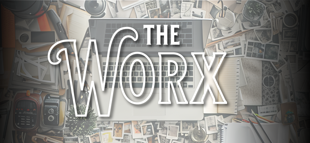 An overhead view of a chaotic creative desk covered in scattered photos, notebooks, pencils, a vintage camera, and a laptop, with the words "The Worx" in large decorative white lettering overlaid.