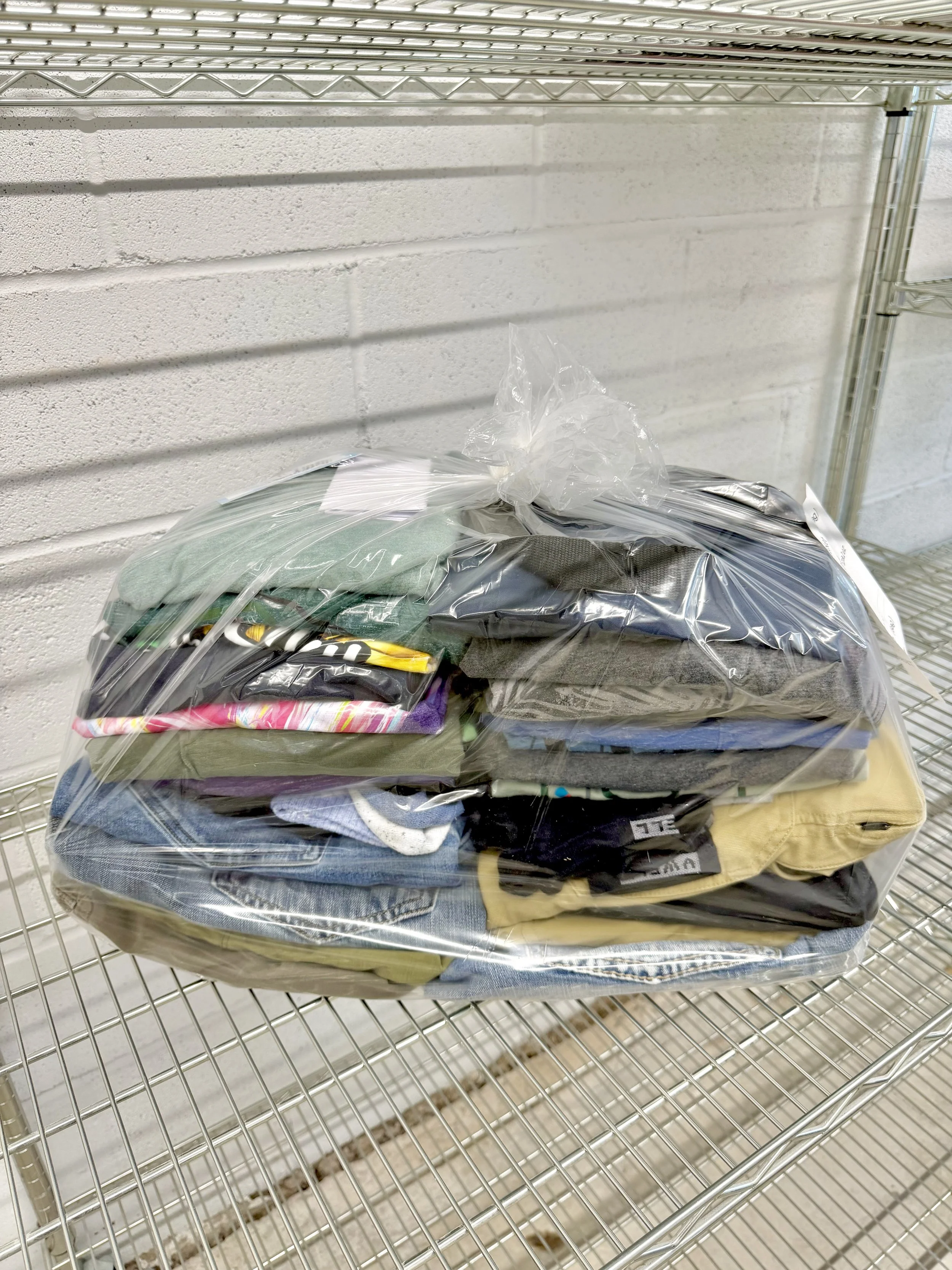 A neatly folded stack of colorful sweaters resting on a smooth surface with soft lighting.