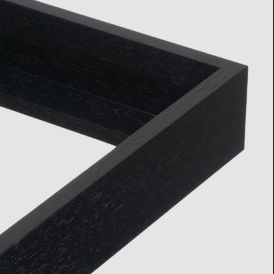 Close-up of a black wooden picture frame corner on a white background.