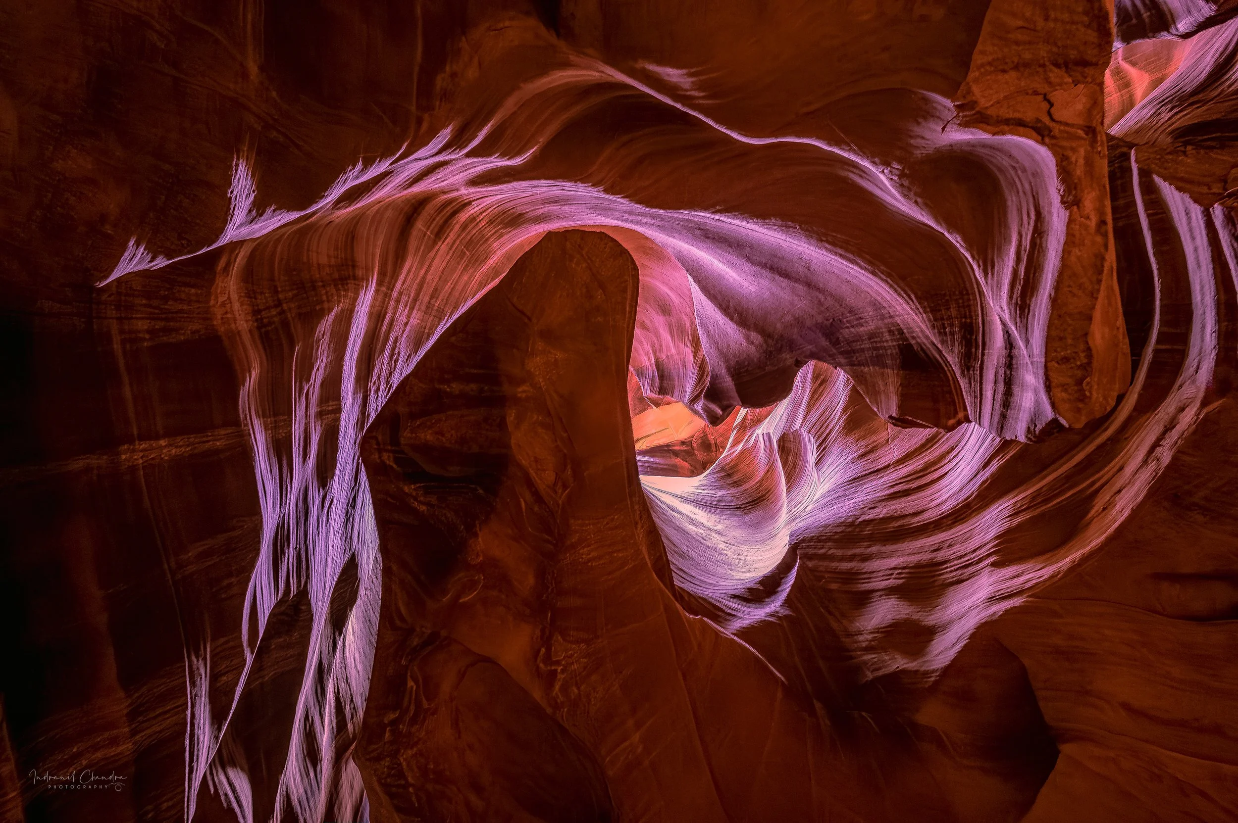 Light dances across the flowing sandstone walls of Antelope Canyon, revealing vivid patterns and colors within its vortex-like formations.