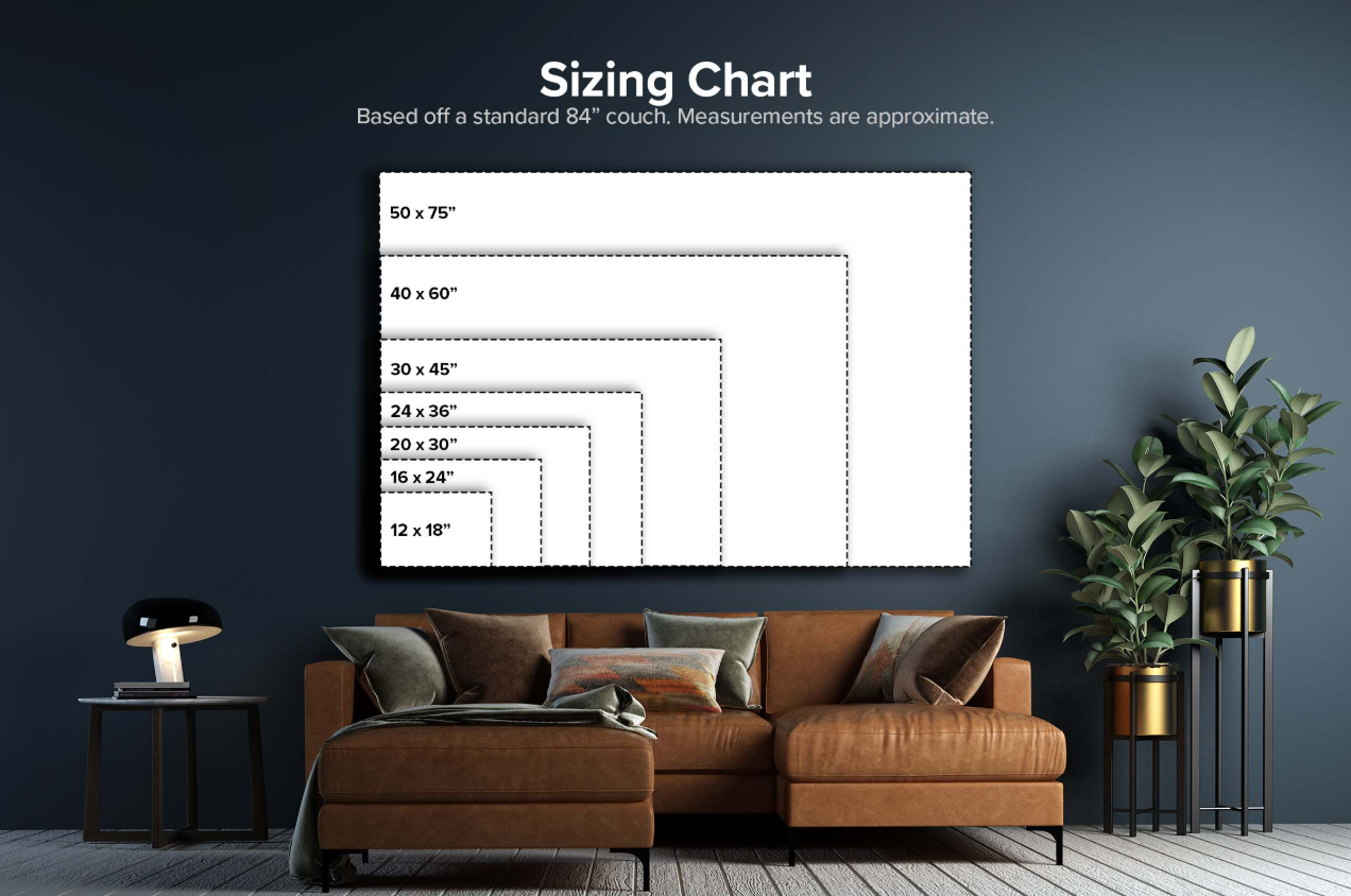Living room with a wall-mounted sizing chart for couches, ranging from 12x18 inches to 50x75 inches, above a brown sectional sofa with pillows, a black side table with a lamp, and tall potted plants on the right.