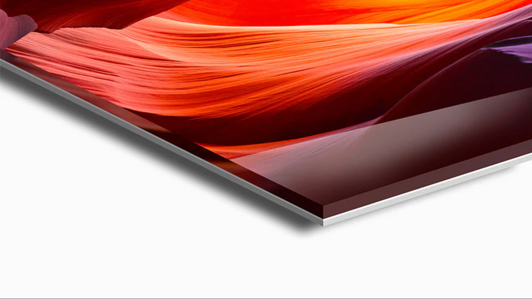 Close-up of a modern flat-screen monitor displaying abstract red and purple art, viewed from a slight angle.