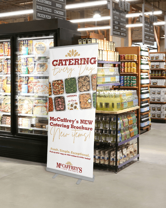 Promotional roll up banner of catering with dishes in frozen aisle at McCaffrey's
