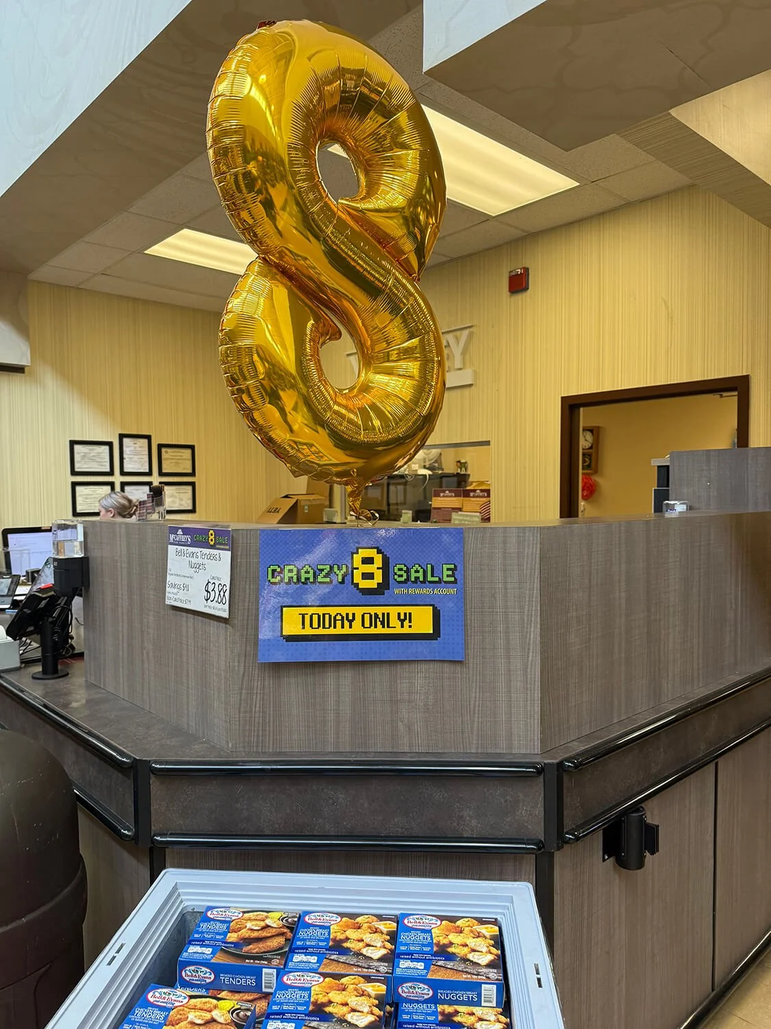 McCaffrey's Crazy 8 sale signage with giant gold 8 balloon in-store