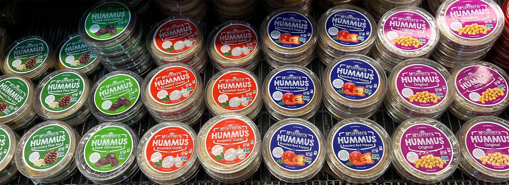 Overhead shot of varieties of McCaffrey's hummus in open cold case