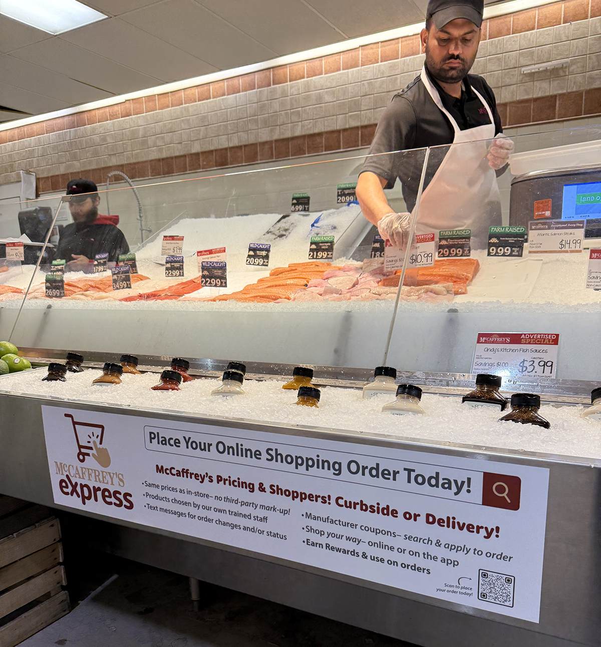 McCaffrey's Express vinyl on open seafood ice case with employee behind