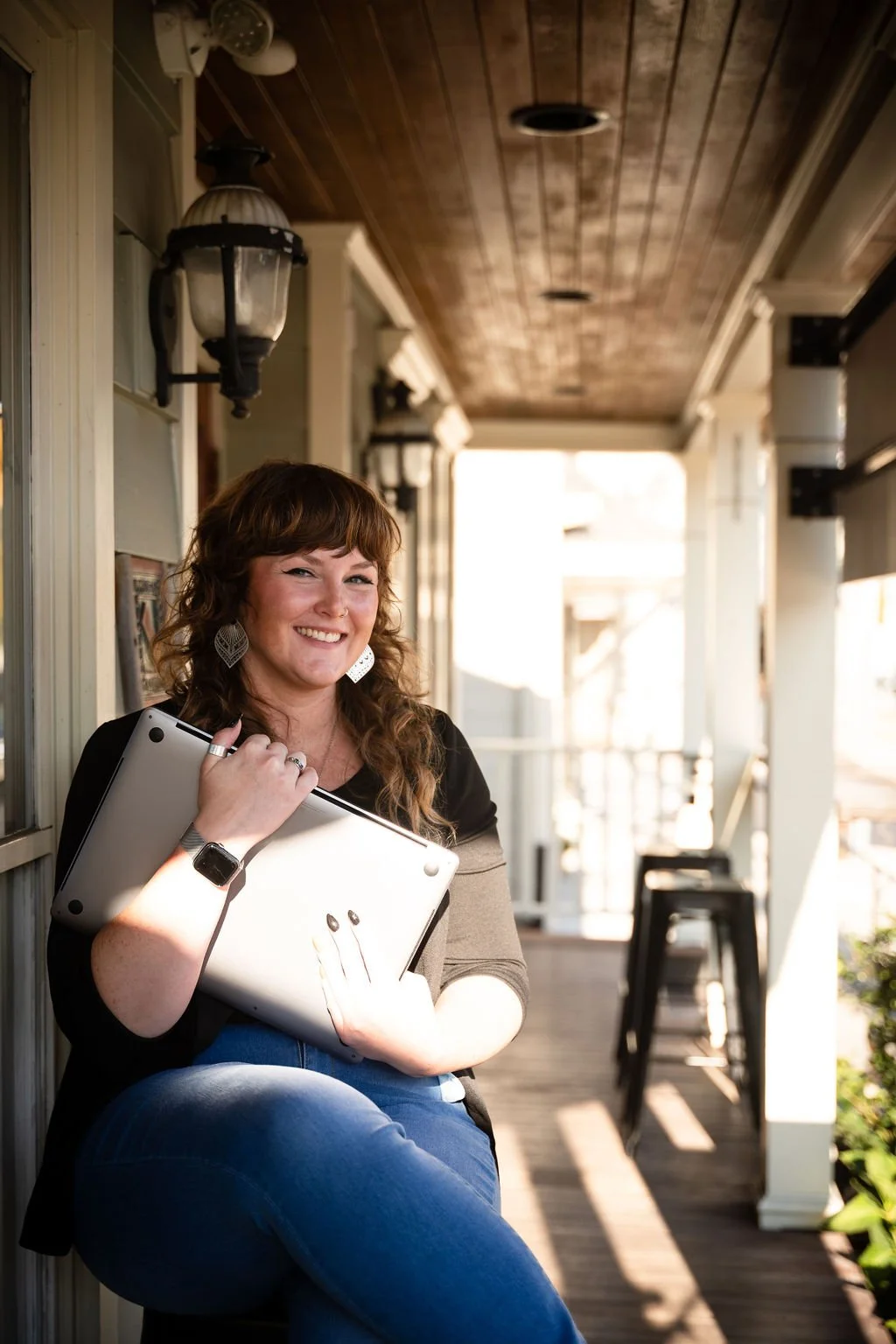 Felicia sitting outside holding laptop