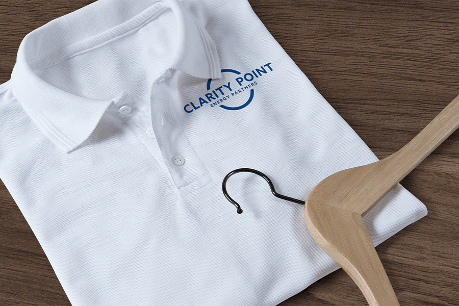 Clarity Point white business polo with logo on the chest. Neatly folded with wooden hanger