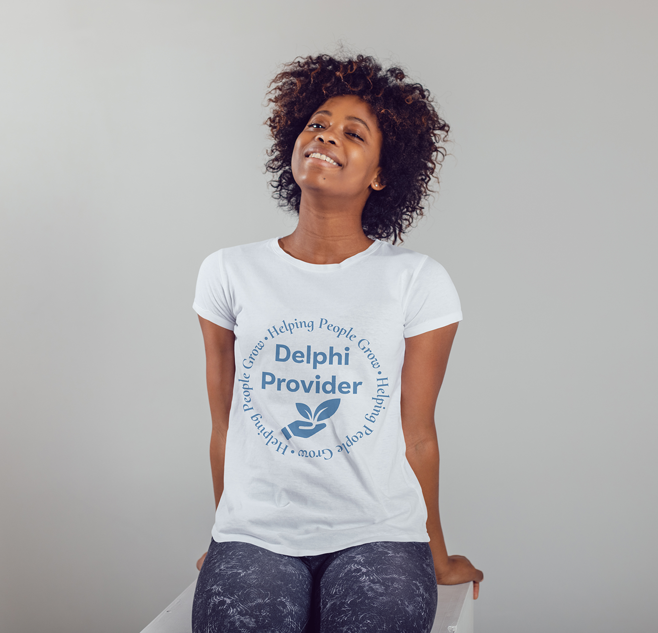 Woman wearing a white Delphi Provider t-shirt, leaning