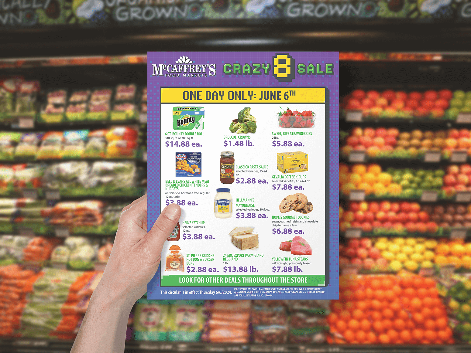 Hand holding up McCaffrey's crazy 8 flyer in front of produce wall