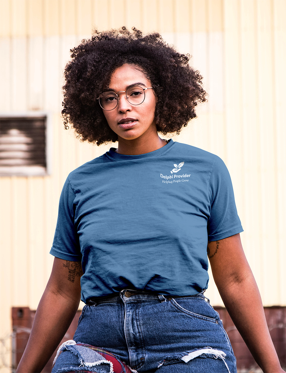 Woman with glasses wearing a blue Delphi Provider shirt tucked into blue jeans