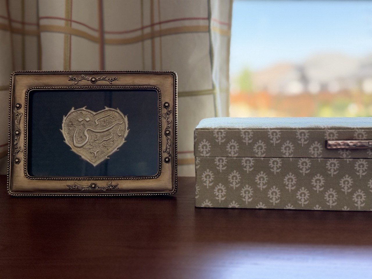 Small gilded frame holding hand-worked Farsi calligraphy of a name, made in Esfahan