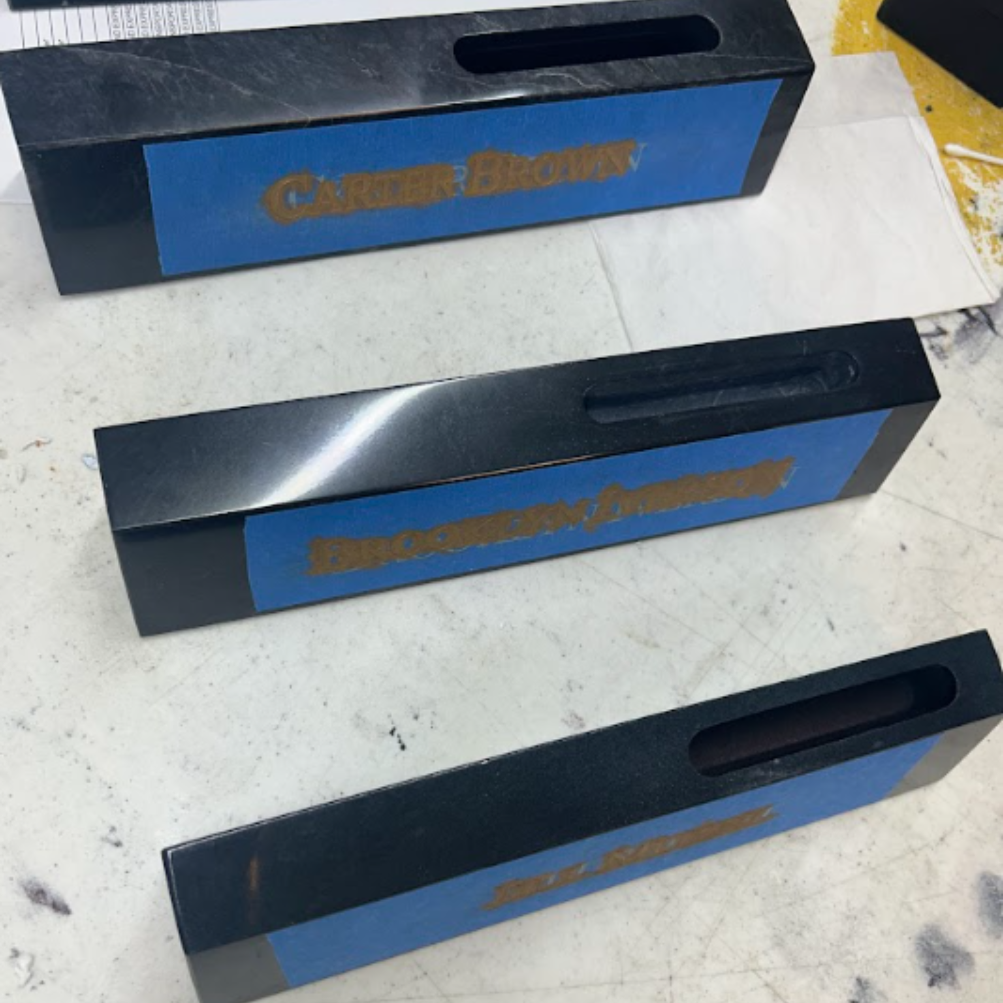 A blue and black card holder with the word 'CARRIER' partially visible on a blue label, placed on a white surface with some black structures around.