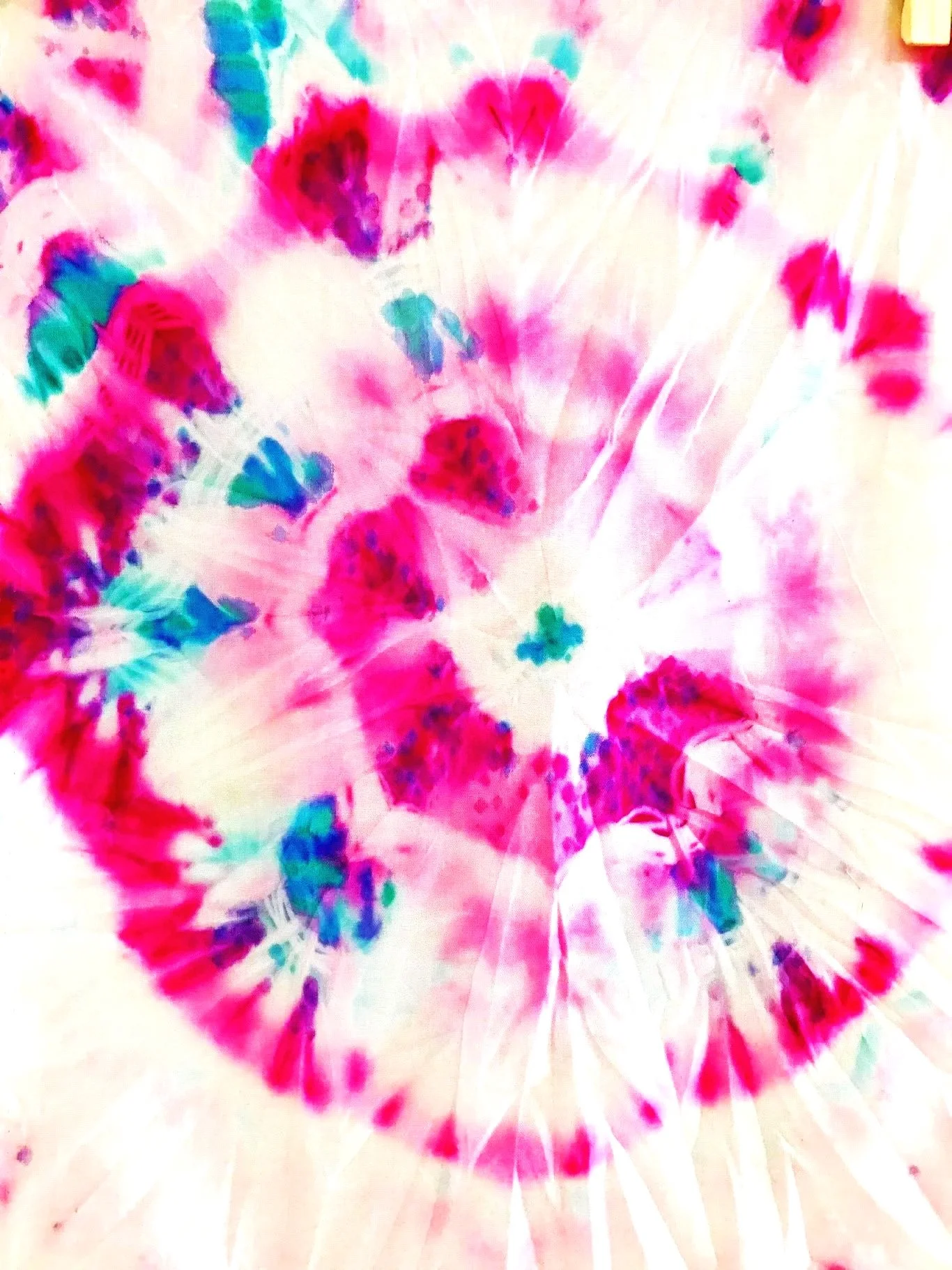 Colorful tie-dye design with vibrant pink, blue, green, and purple spiral patterns.