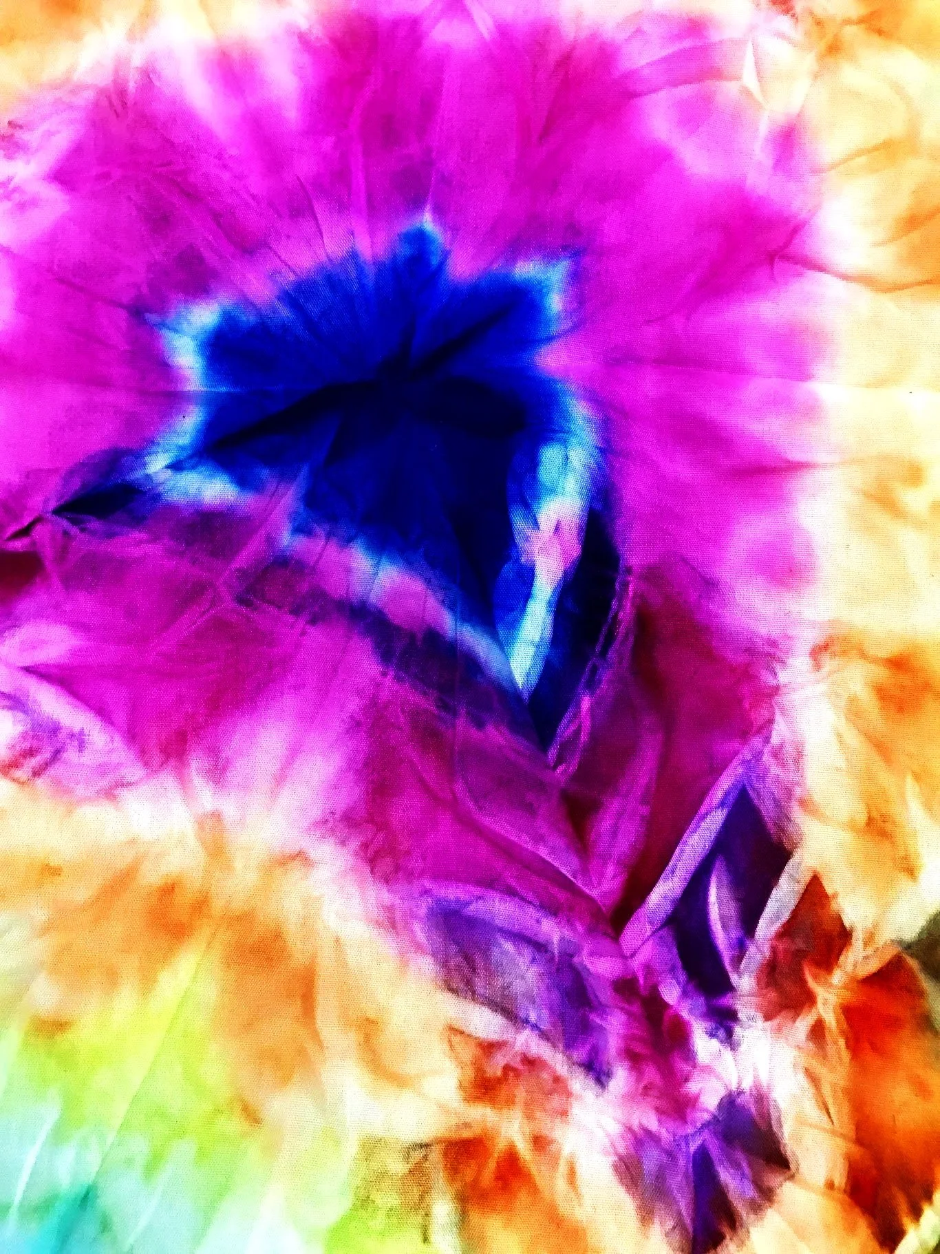 Close-up of a colorful, abstract painting with hues of purple, blue, yellow, green, and orange.