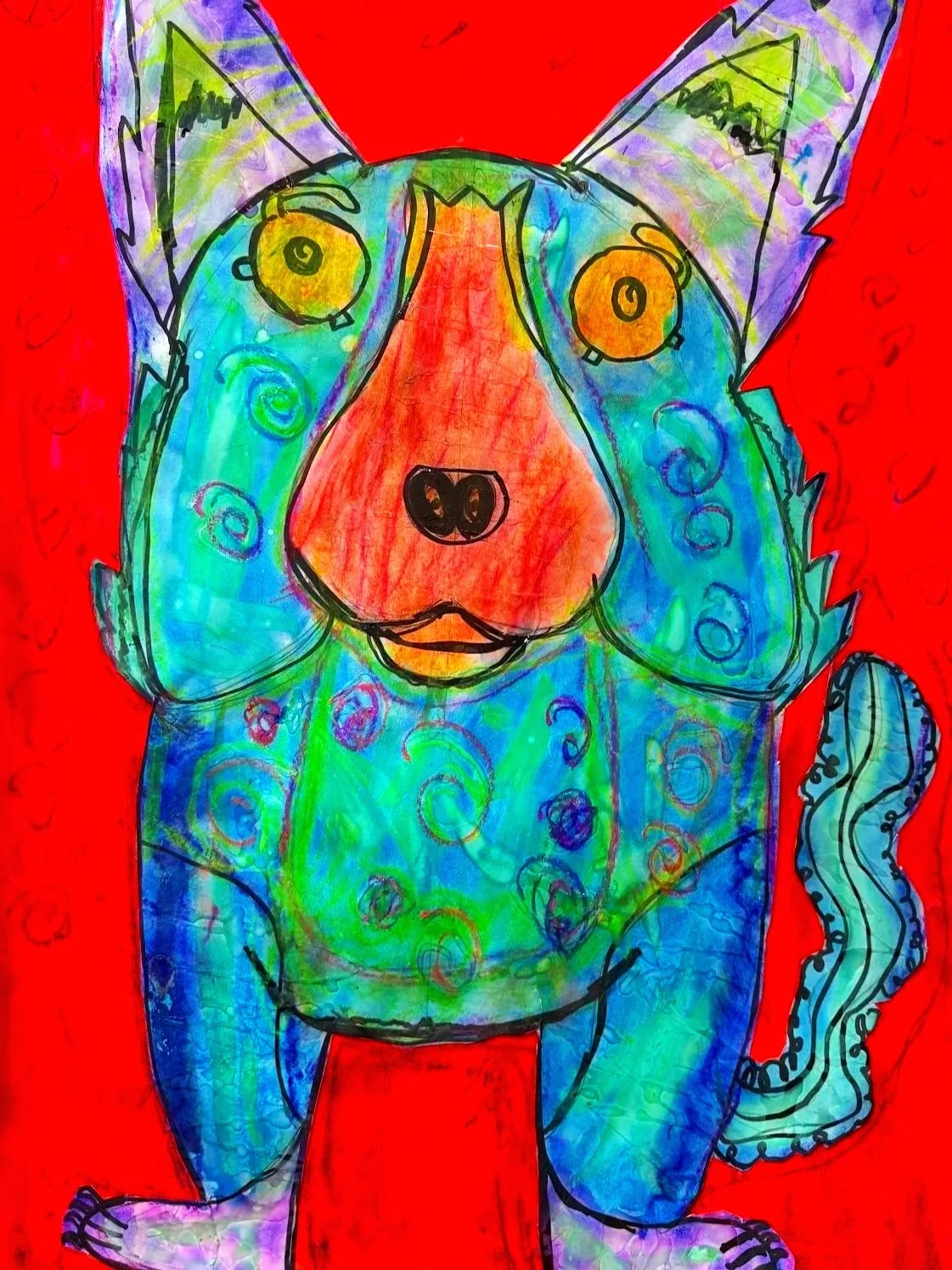 Colorful children's drawing of a dog with large ears, a blue body with swirling patterns, orange face, yellow eyes, and a curly tail, set against a red background.