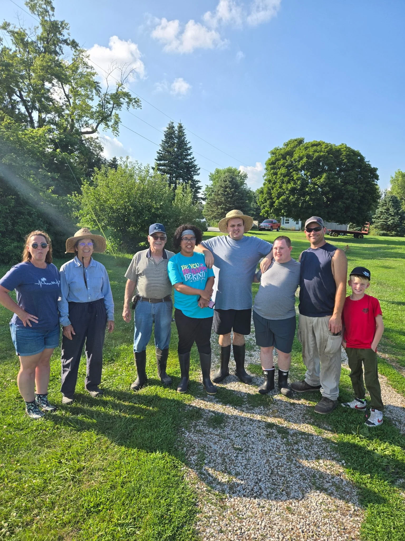 Participants from Kindness Opportunities volunteering together at R&L Farm while helping care for the animals.
