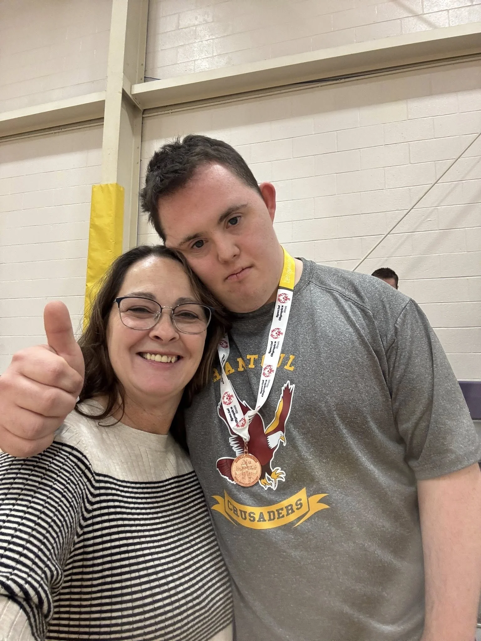 Chance gives a thumbs up while wearing a medal he earned at a Special Olympics event.