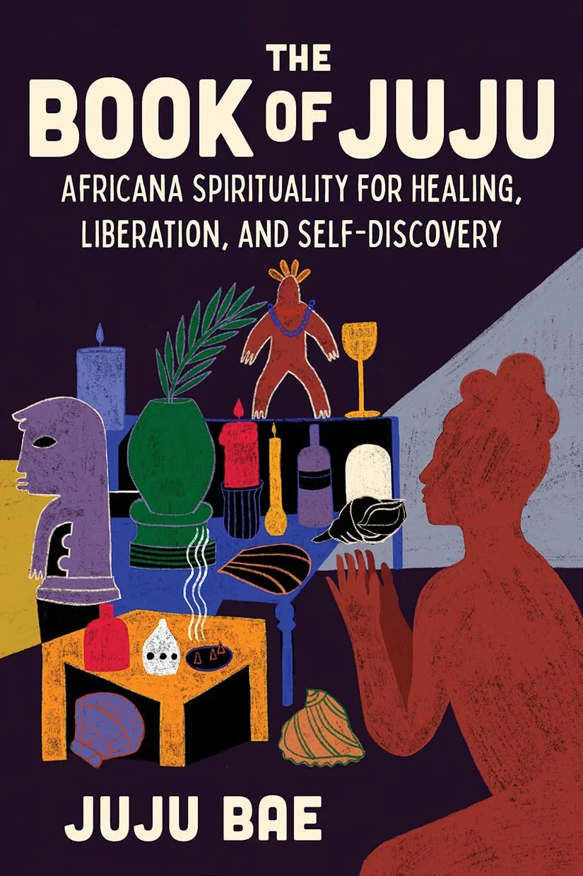 Cover of 'The Book of Juju: Africana Spirituality for Healing, Liberation, and Self-Discovery' featuring a woman with reddish skin and natural hair, sitting at a table with various objects such as candles, shells, and bottles, surrounded by African-inspired art and symbols.