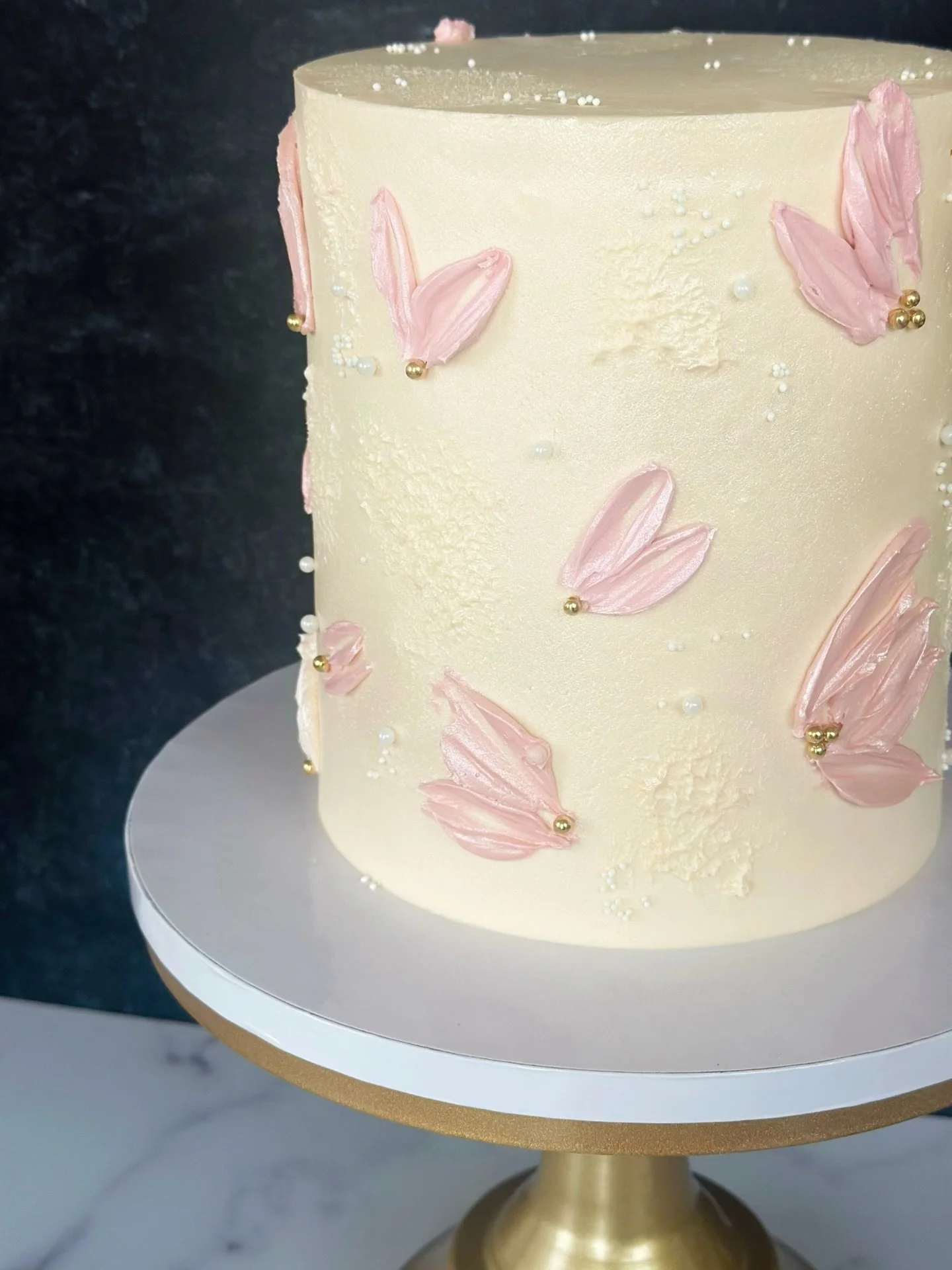 As much as I love a maximalist, multi-color, vintage piping cake, I equally love cakes like this&mdash;with subtle buttercream palette knife florals and delicate pearl detailing.  Minimal, elegant, and with just enough flair to stand out and leave an