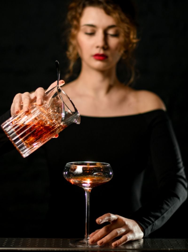 Bartender preparing a refined cocktail in a luxury hospitality setting, representing performance optimisation and service excellence in food and beverage operations.