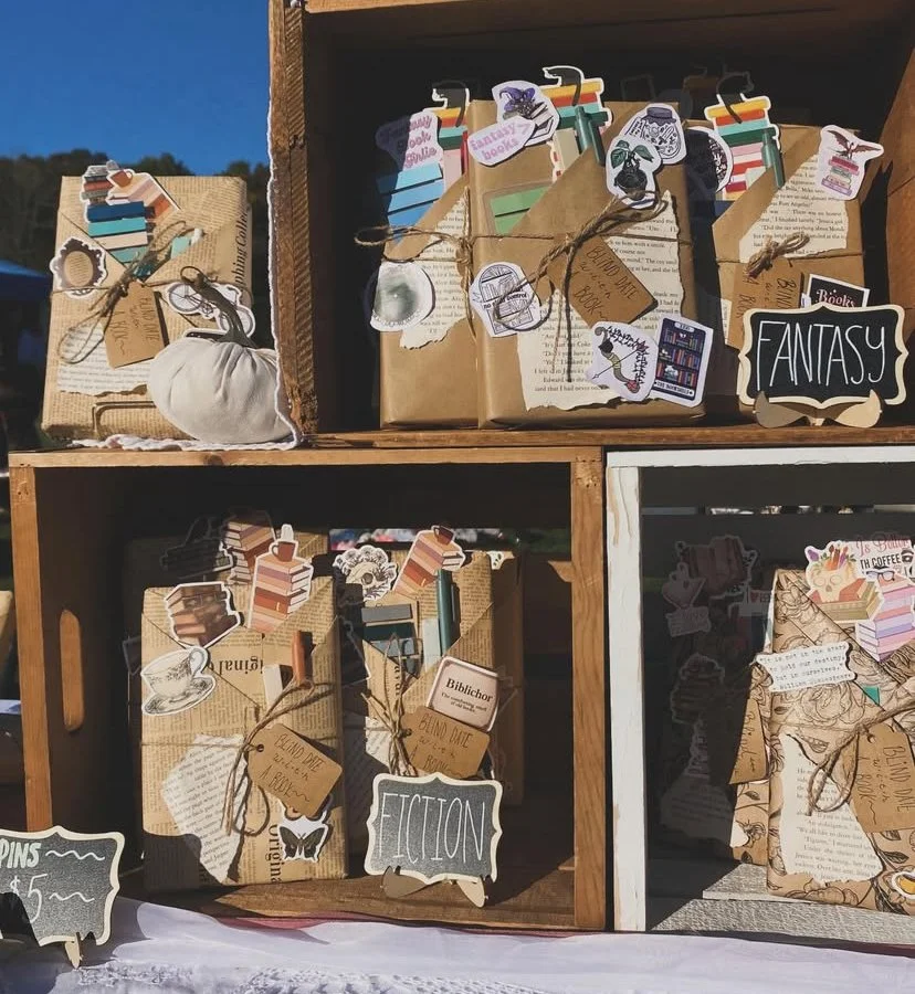 Craft display of books and themed tags arranged in wooden boxes, labeled with 'FANTASY' and 'FICTION'.
