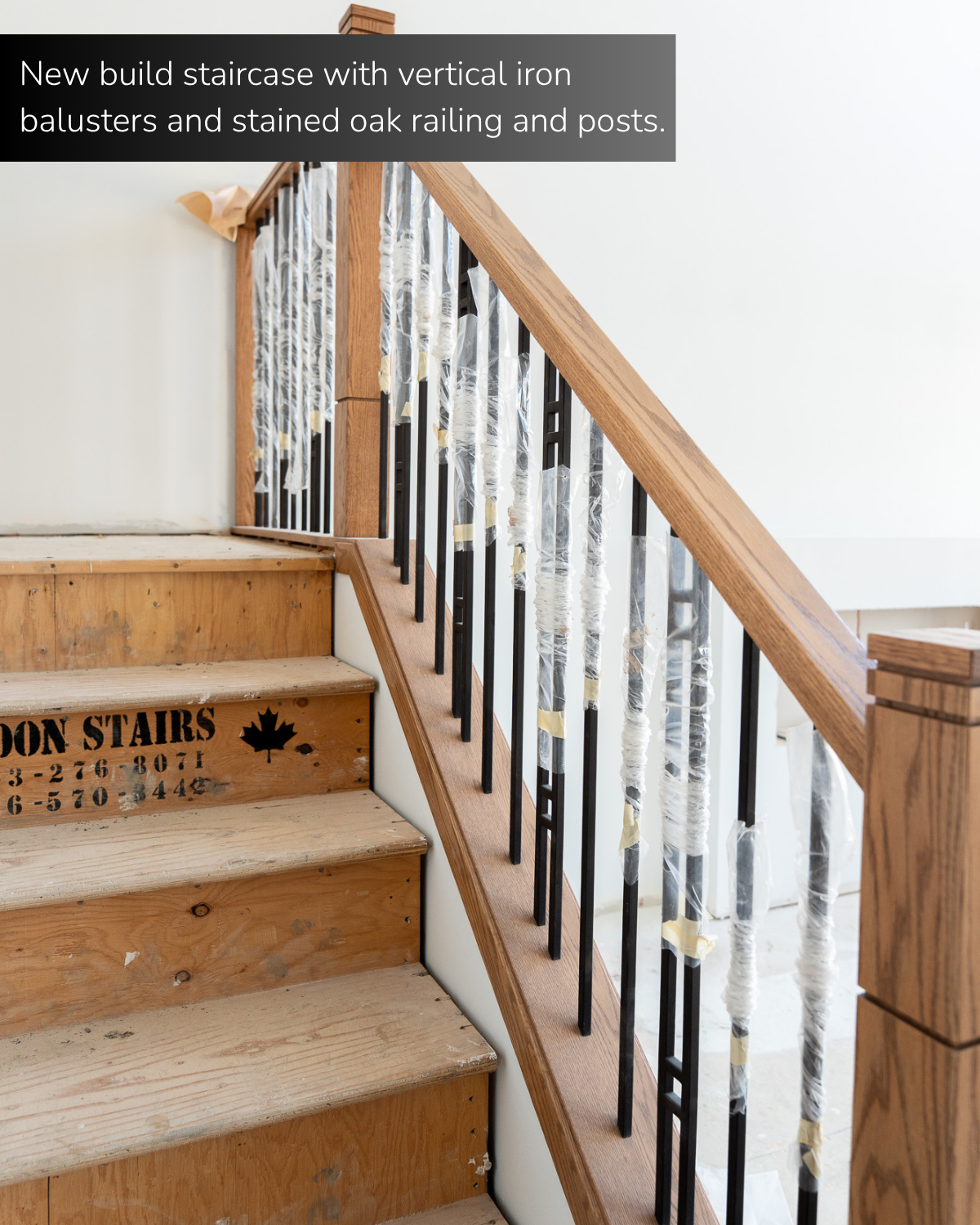 new build staircase with vertical iron balusters and stained oak railing and posts. 