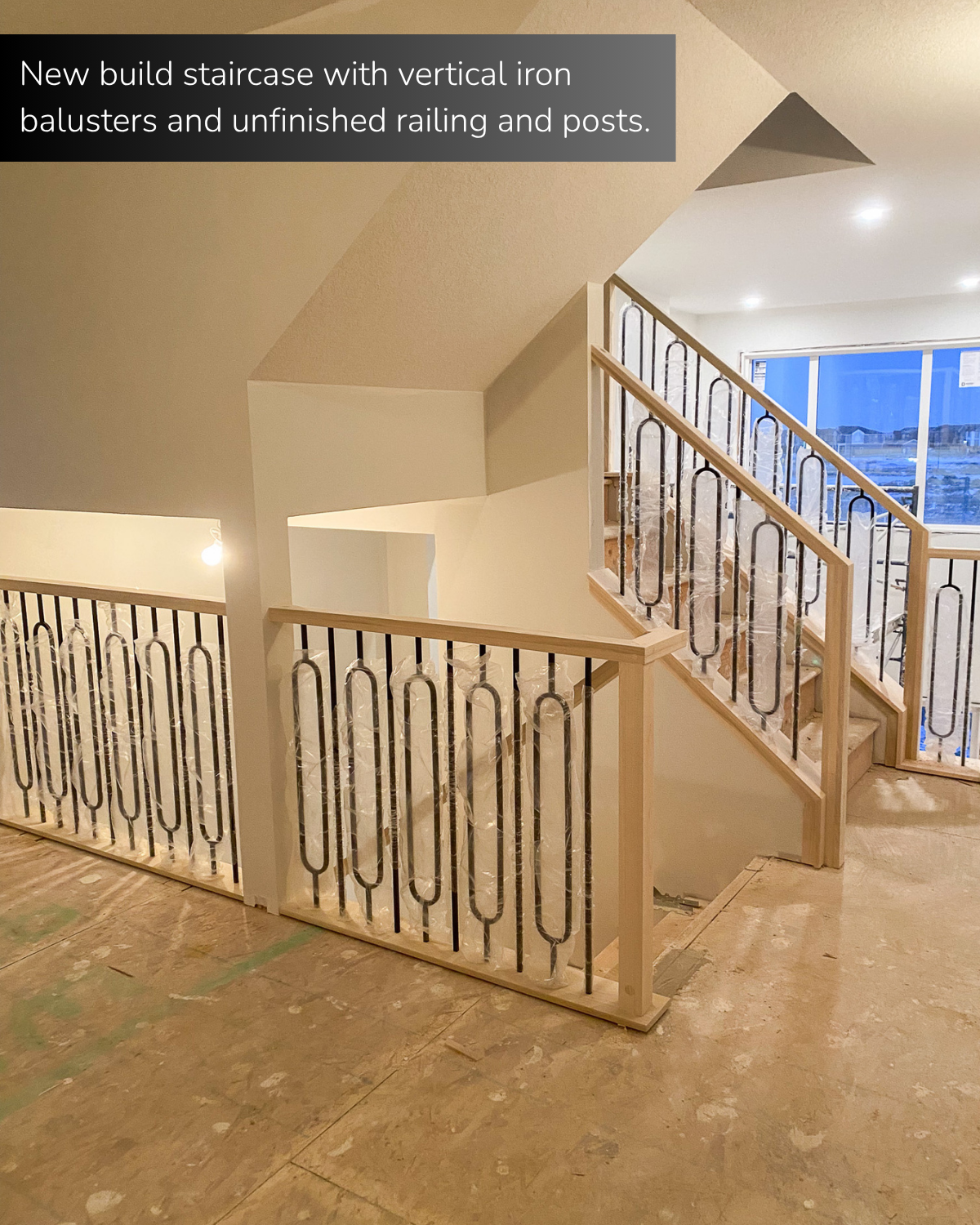 New build staircase with vertical iron balusters and unfinished railing and posts. 