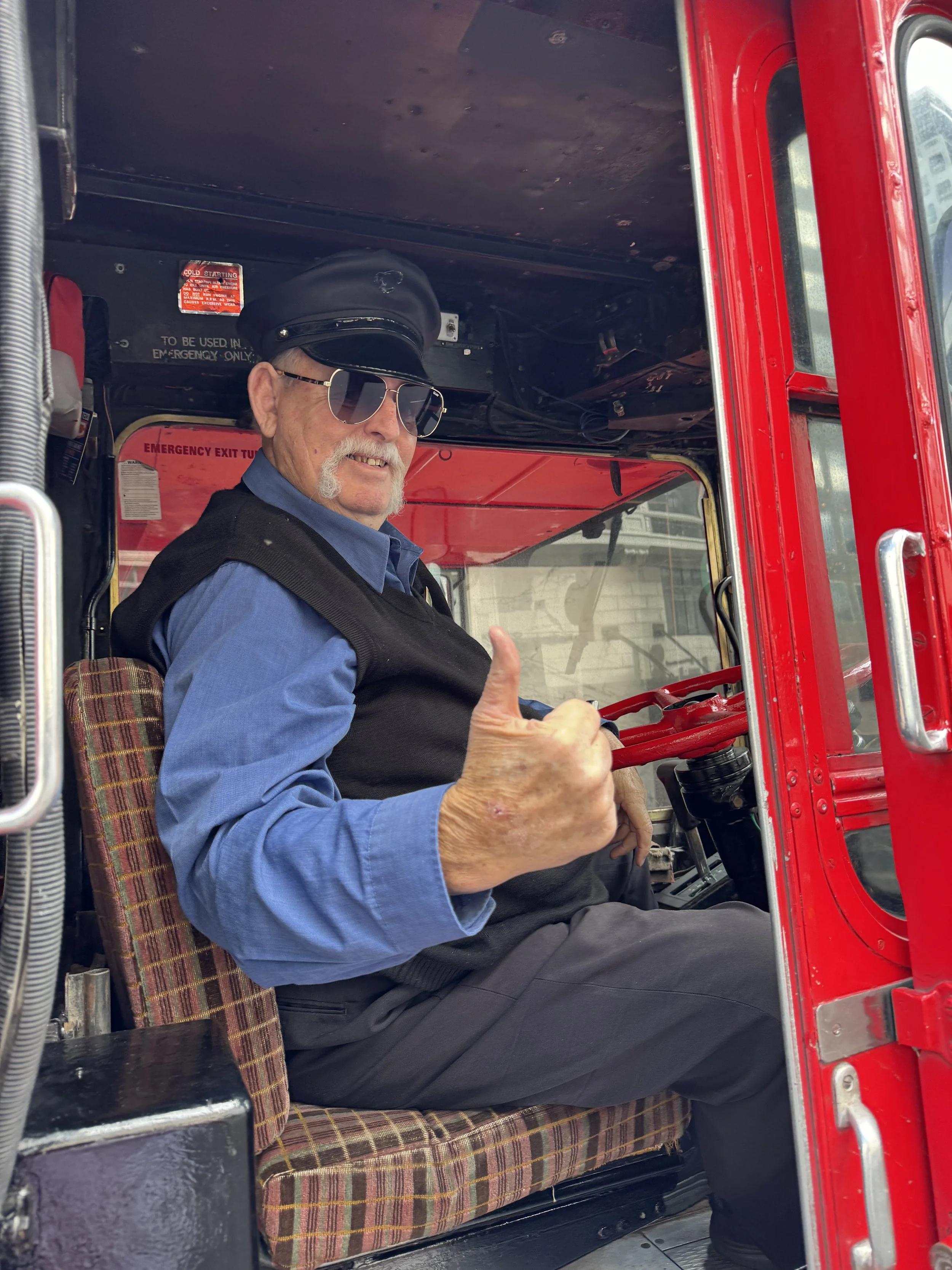 The driver at the wheel of the restored Routemaster, ready to begin another scenic Auckland tour.