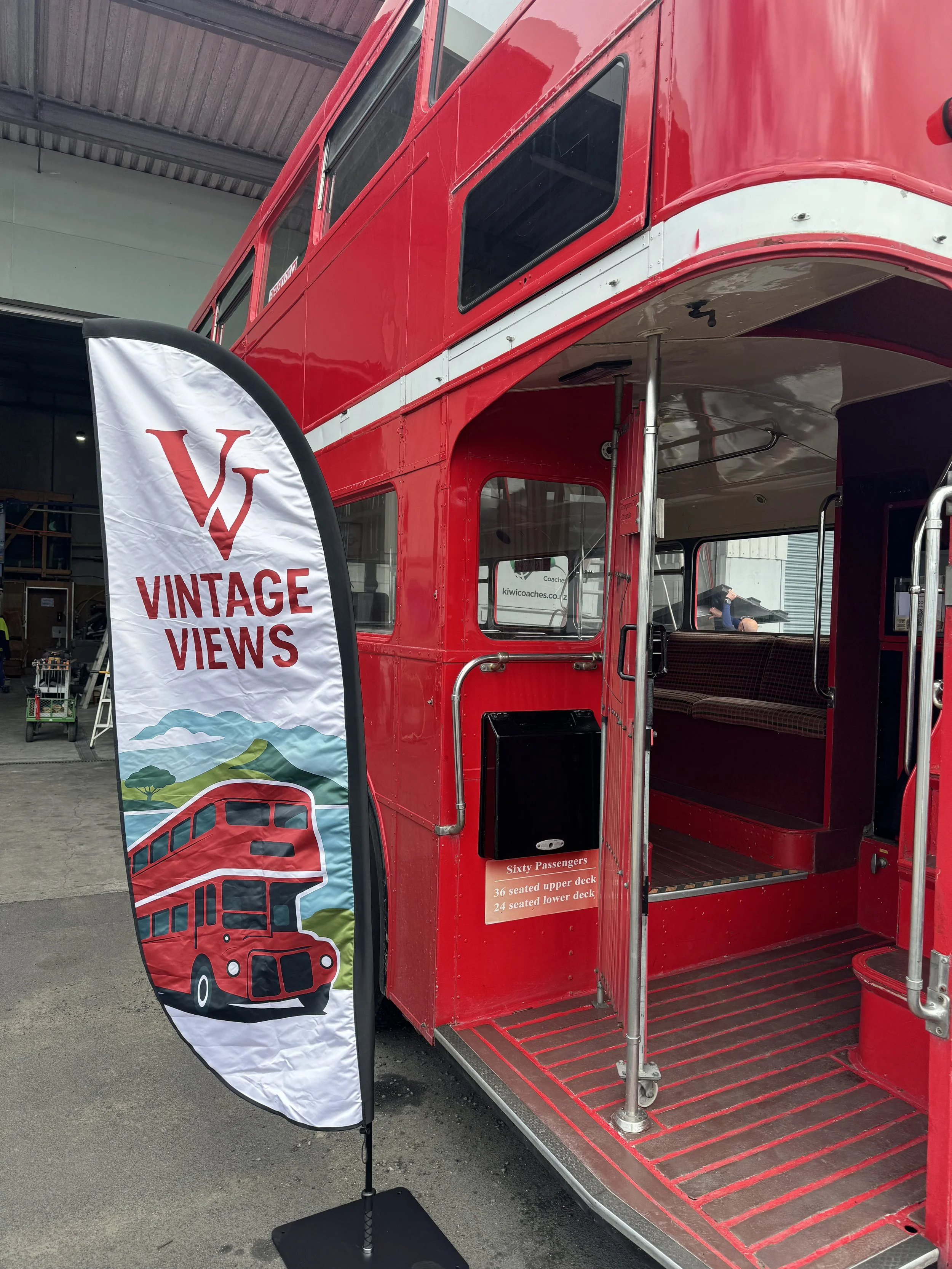 A beautifully restored red double-decker bus parked beside Viaduct Harbour during the Auckland city sightseeing tour.