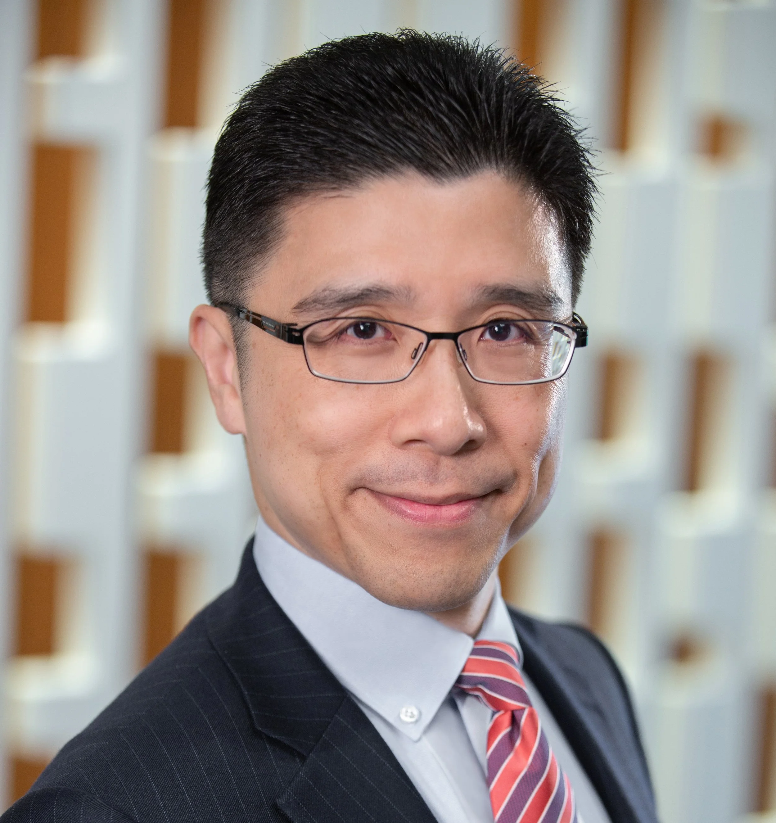 Jim Guo, Founder and CEO of Ollleaders, an Asian man wearing a suit and glasses