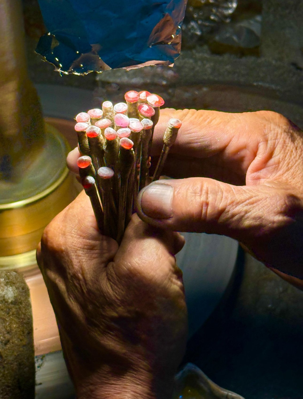 Close-up of hands holding polished gemstones.