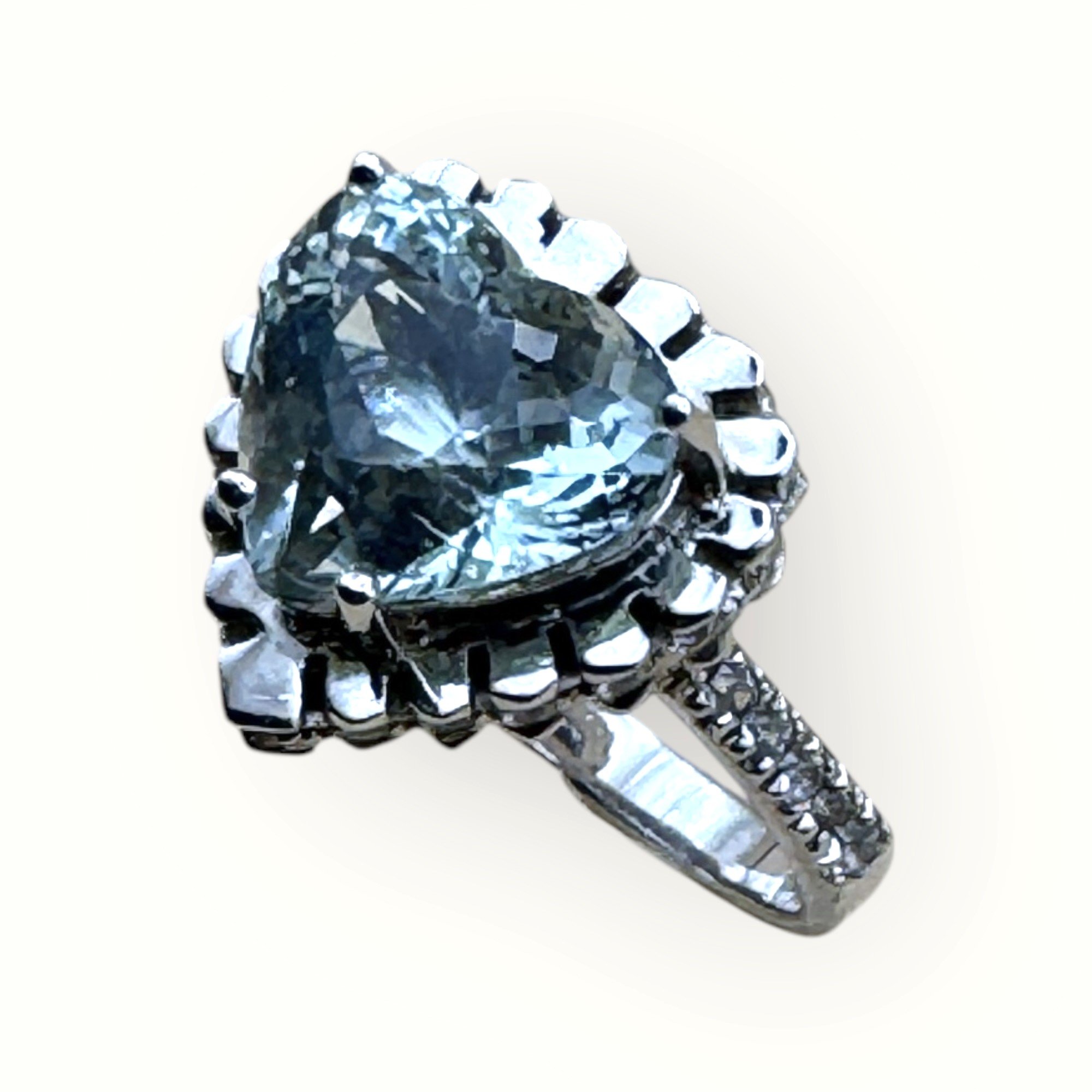 Silver ring with a large, heart-shaped diamond centerpiece and smaller diamonds on the band.