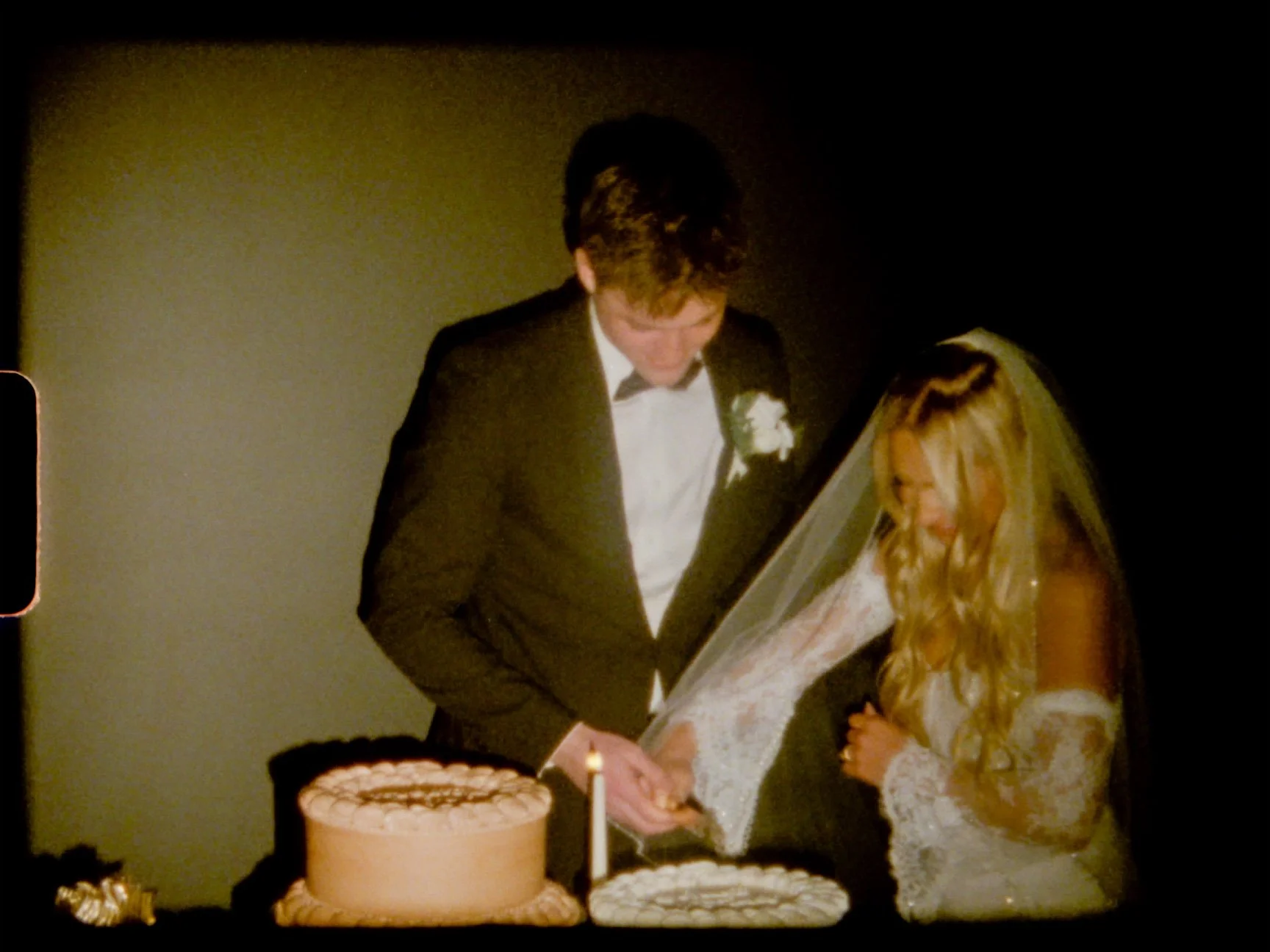 Super 8 film still of newlyweds cutting their wedding cake at an intimate backyard wedding in St. Louis, Missouri