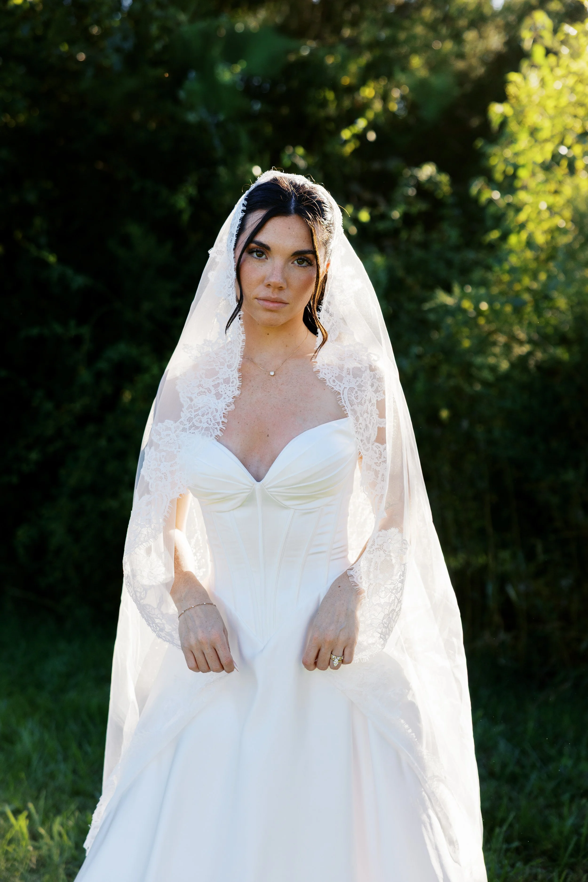 Bride in lace veil photographed outdoors at a Kansas wedding by documentary wedding photographer Melissa Ann Photographs