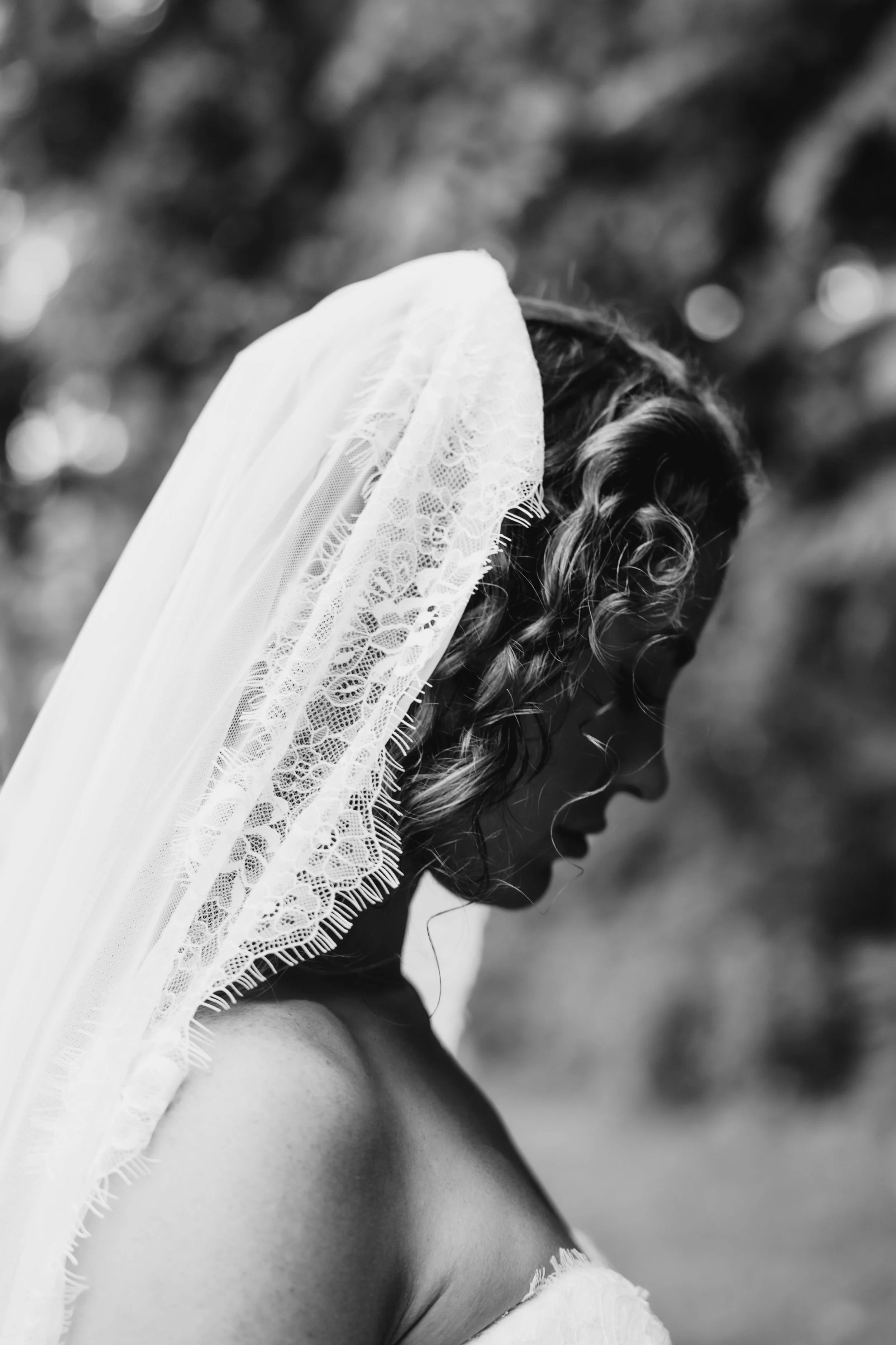 Black-and-white bridal portrait beneath her veil during an intimate backyard wedding in Missouri.