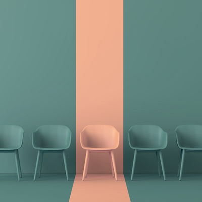 Three chairs with one highlighted in a different color, symbolizing reactive hiring practices that lead to rushed decisions and missed strategic growth opportunities.