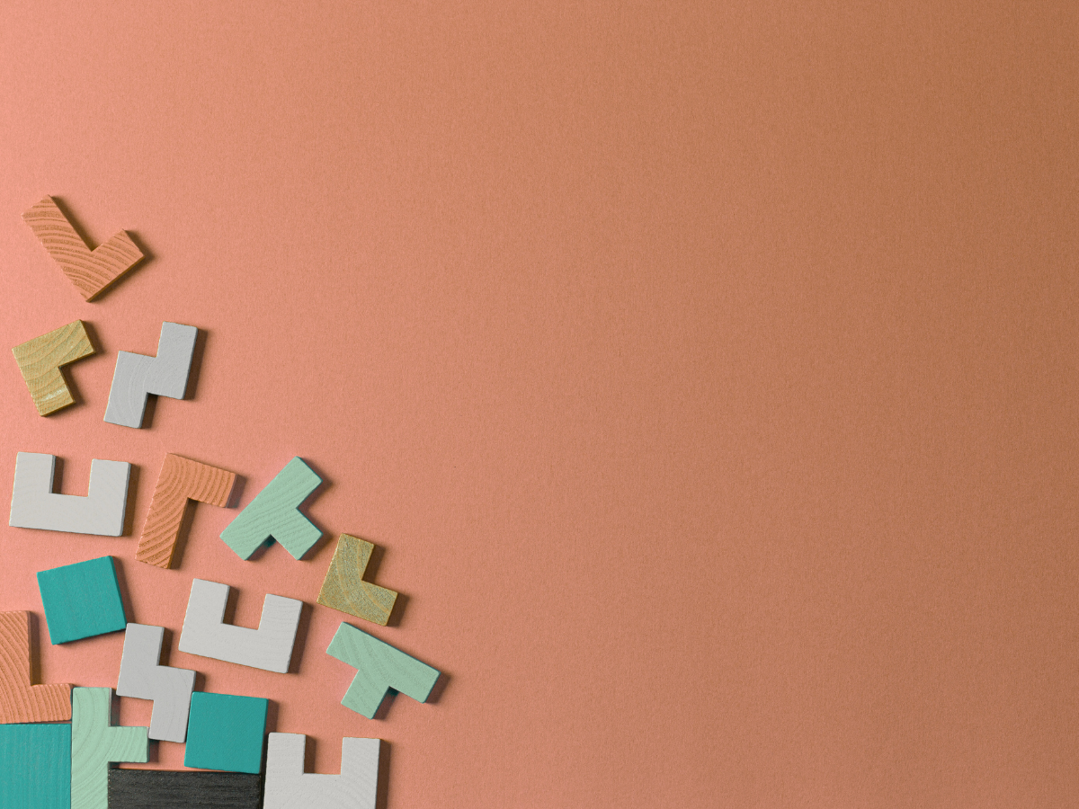 Colorful puzzle pieces on an orange background representing SonderWorks’ hands-on execution of HR systems, policies, and onboarding.