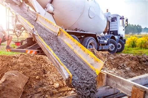 Concrete being poured from a cement mixer truck into a form on a construction site.