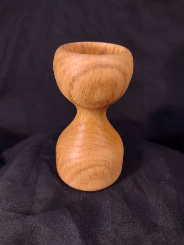 A wood bowl round on top with a rounded base.
