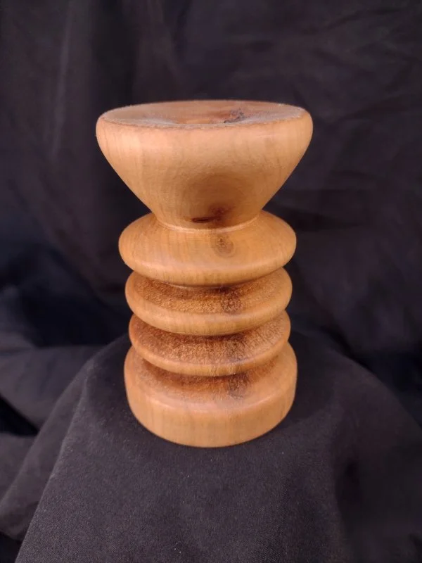 Turned wood with unique shape and central hole.