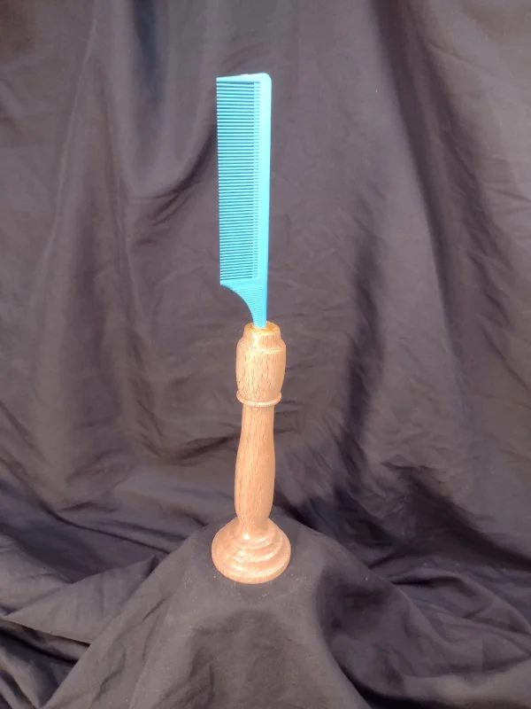 A wood handled comb that sits upright.