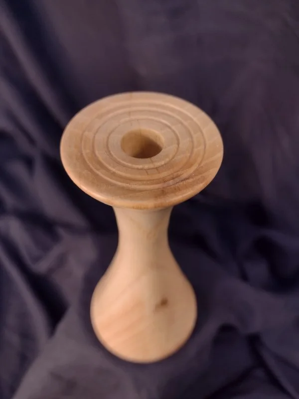 Turned wood with unique shape and central hole.