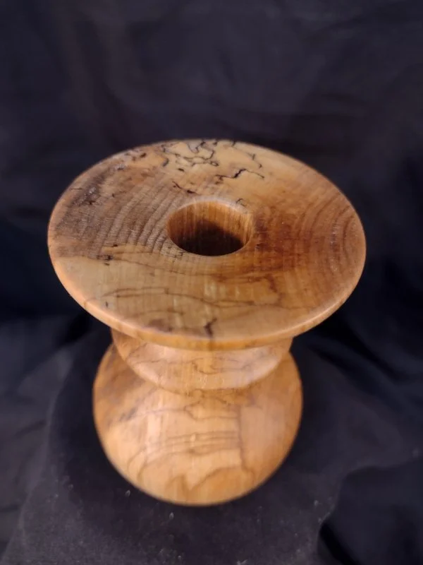 Turned wood with unique shape and central hole.