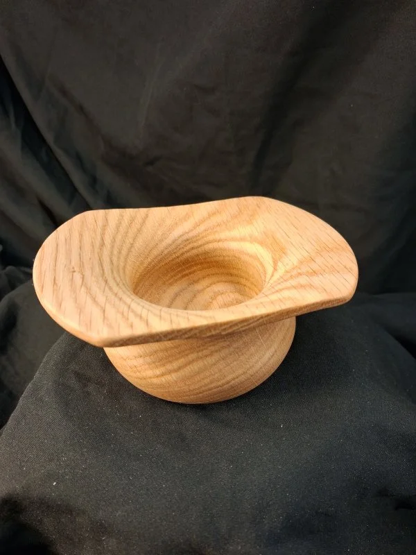 Wood bowl with a round, wide opening and tapered base.