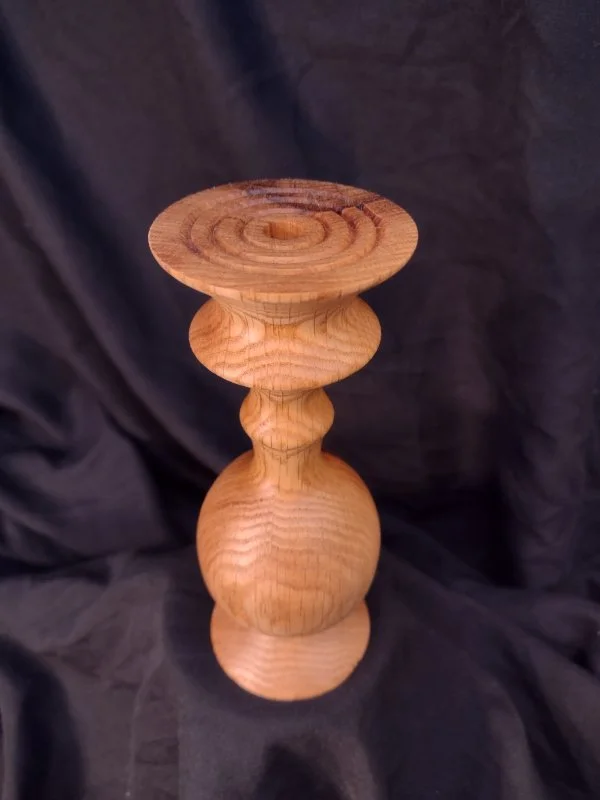 Turned wood with unique shape and central hole.
