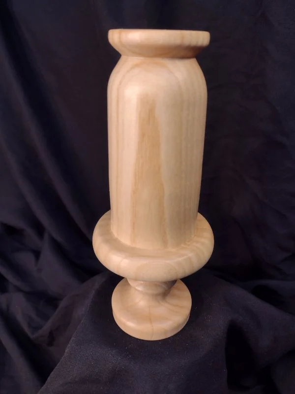 Turned wood with unique shape and central hole.