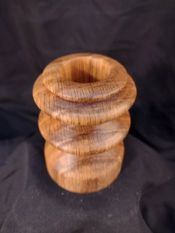 Turned wood with unique shape and central hole.