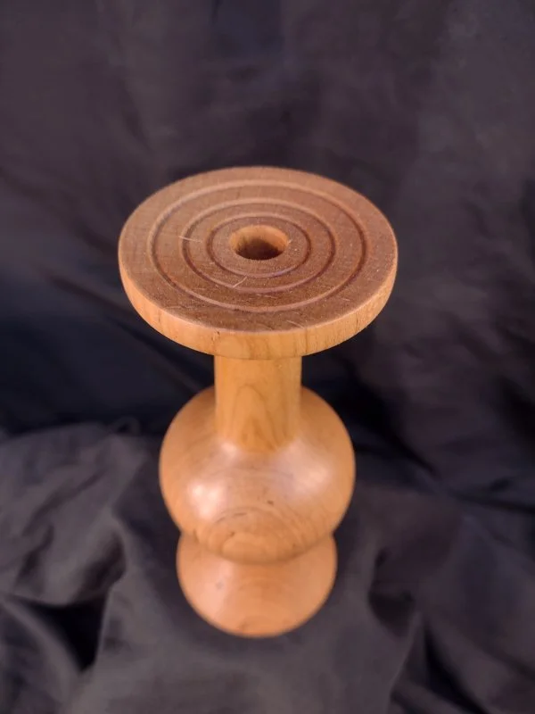 Turned wood with unique shape and central hole.