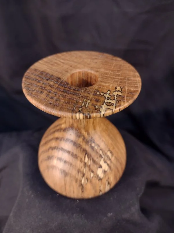 Turned wood with unique shape and central hole.